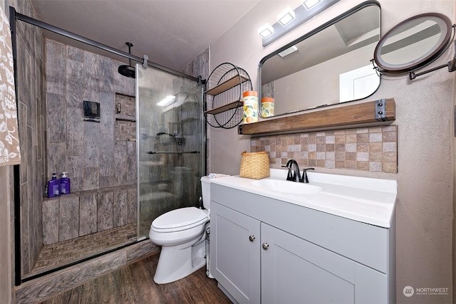 bathroom with hardwood / wood-style floors, toilet, an enclosed shower, and vanity