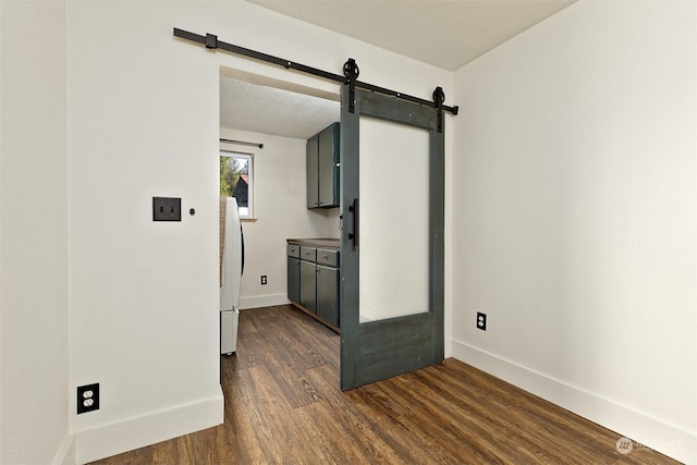 kitchen with a textured ceiling, white refrigerator, dark wood-type flooring, and gray cabinetry