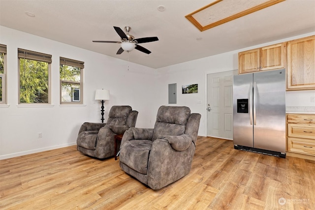 sitting room with electric panel, light hardwood / wood-style floors, and ceiling fan