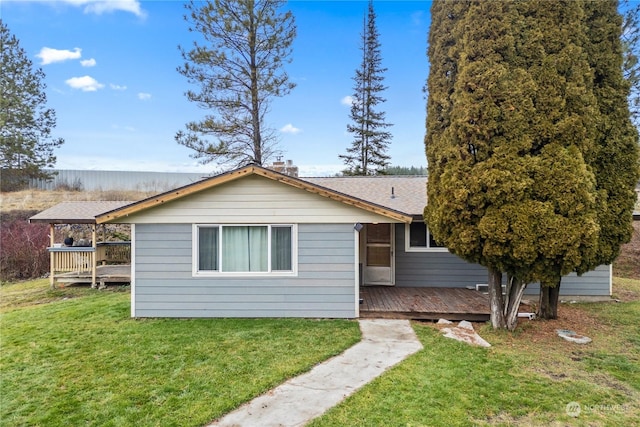 view of side of home with a yard and a wooden deck