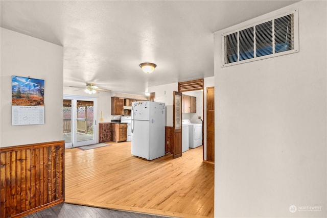 kitchen with light wood-type flooring, washer / dryer, white appliances, and ceiling fan