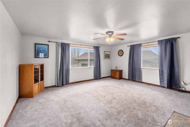 carpeted spare room featuring ceiling fan