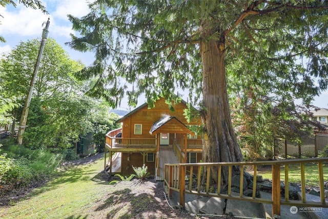 view of front of property with a wooden deck and a front lawn