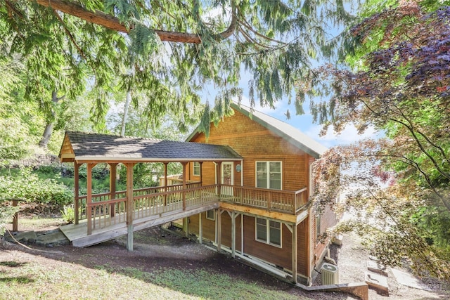 back of property featuring a wooden deck and cooling unit