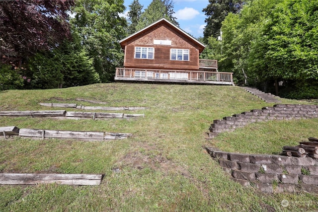 rear view of property with a lawn and a deck