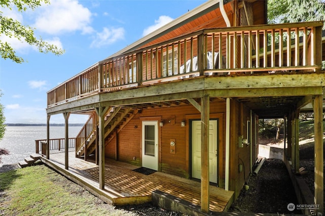 back of property featuring a deck with water view