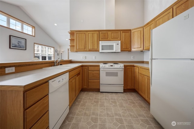 kitchen with vaulted ceiling, kitchen peninsula, sink, and white appliances