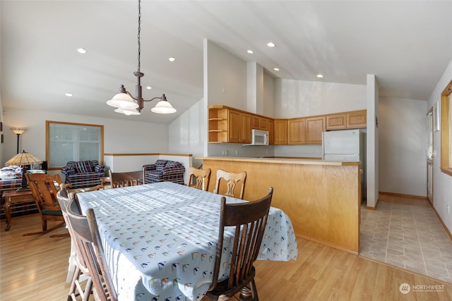 dining room with a chandelier, light hardwood / wood-style floors, and high vaulted ceiling