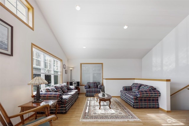 living room with light hardwood / wood-style floors and high vaulted ceiling