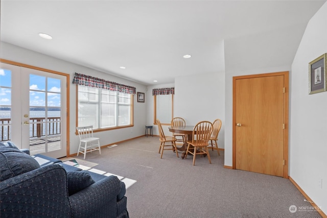 living room featuring french doors, light colored carpet, and vaulted ceiling