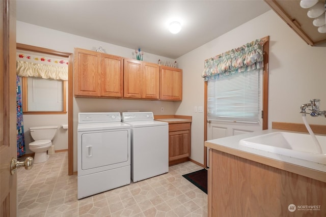 washroom with cabinets, light tile patterned floors, washer and clothes dryer, and sink