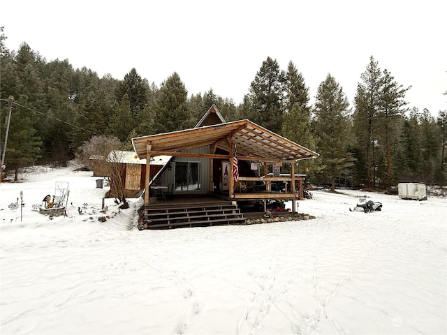 snow covered house featuring a deck