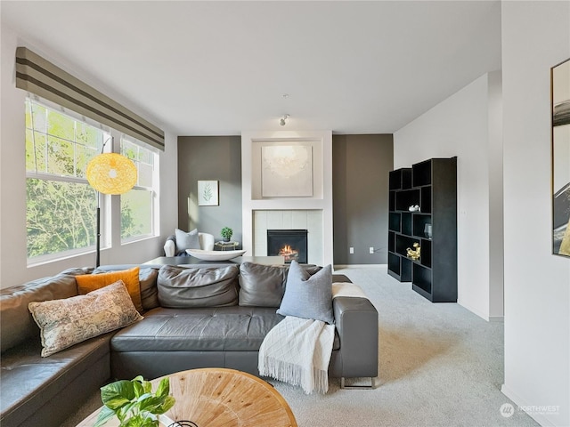 carpeted living room featuring a tiled fireplace