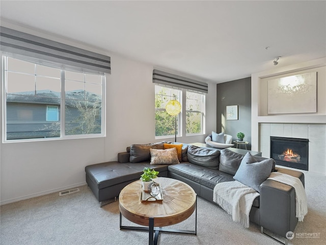 carpeted living room featuring a tile fireplace