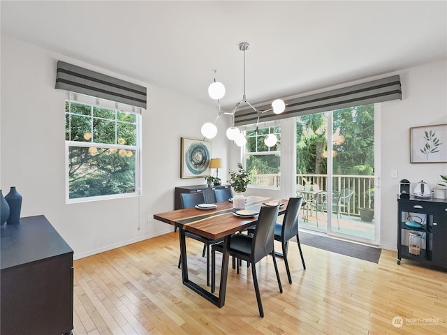 dining area with light wood-type flooring and a healthy amount of sunlight