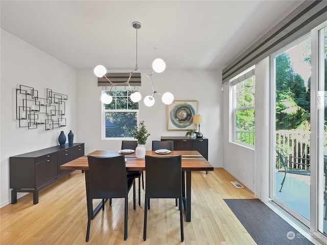 dining room featuring a notable chandelier and light hardwood / wood-style flooring