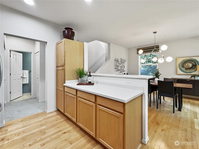 kitchen with decorative light fixtures and light wood-type flooring