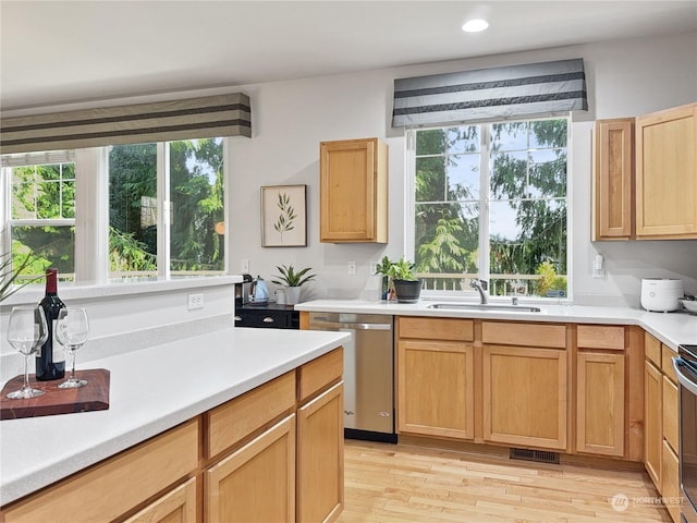 kitchen with stainless steel appliances, light hardwood / wood-style floors, light brown cabinets, and sink