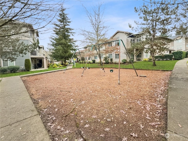 view of community featuring a playground and a lawn