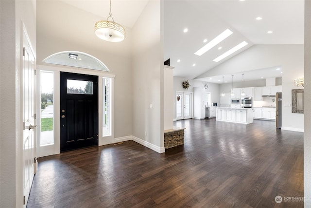 foyer entrance with dark hardwood / wood-style floors and high vaulted ceiling