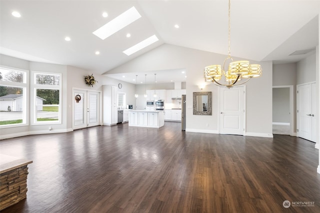 unfurnished living room with a skylight, dark wood-type flooring, high vaulted ceiling, and a chandelier