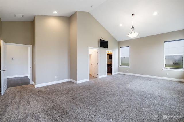 carpeted empty room featuring high vaulted ceiling