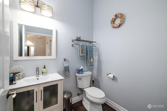 bathroom featuring wood-type flooring, vanity, and toilet