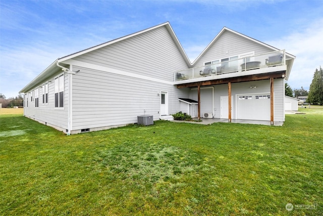 back of house with a yard, a balcony, a garage, and cooling unit