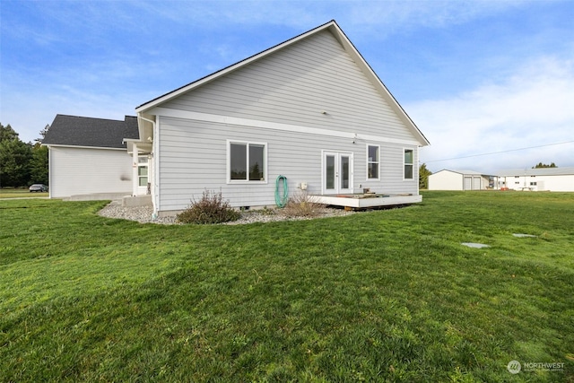 rear view of house featuring a yard, a wooden deck, and french doors