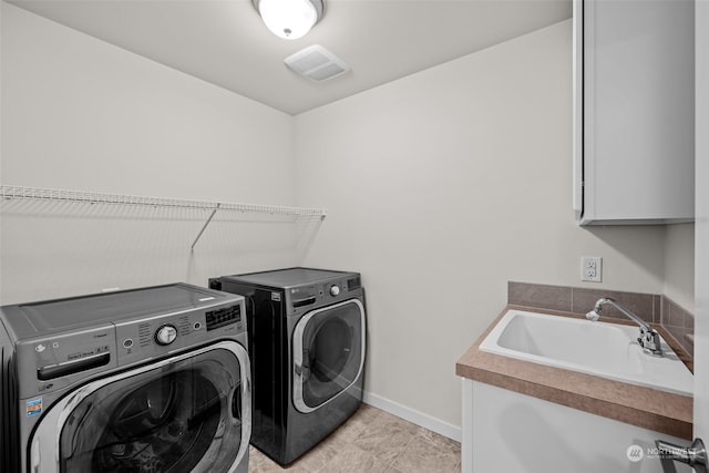 laundry area featuring cabinets, independent washer and dryer, and sink