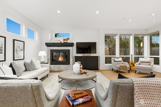 living room featuring light hardwood / wood-style floors and a tiled fireplace