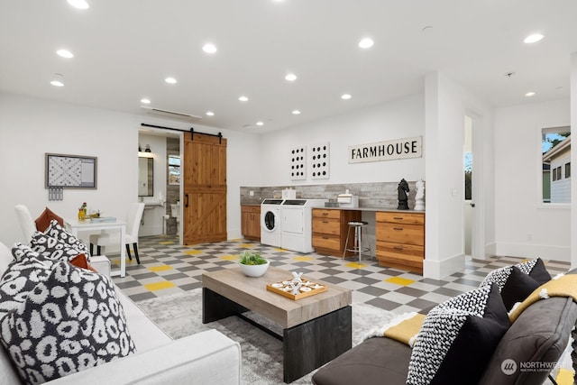 living room with separate washer and dryer and a barn door