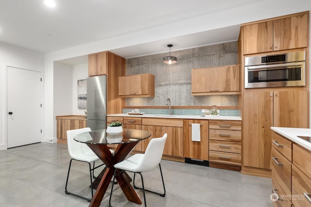 kitchen featuring stainless steel appliances, decorative light fixtures, and sink