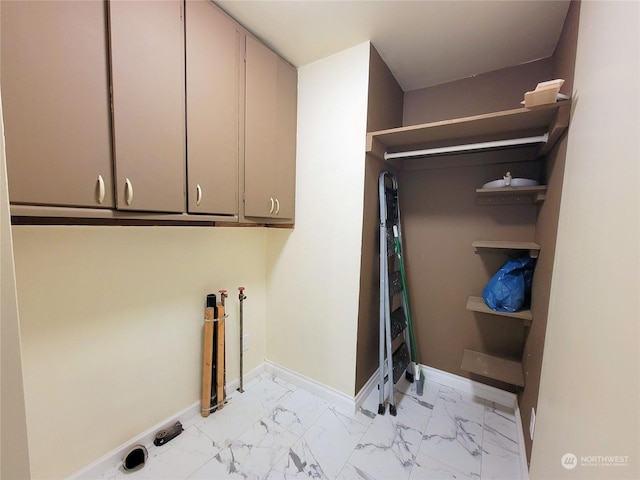 clothes washing area with cabinets