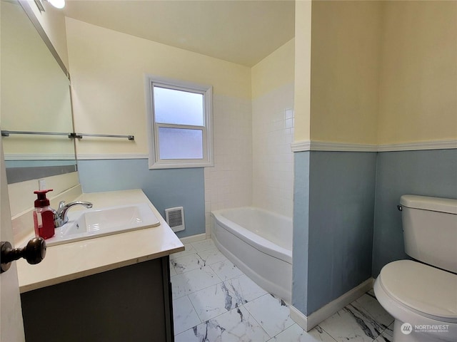 bathroom featuring vanity, toilet, and a washtub