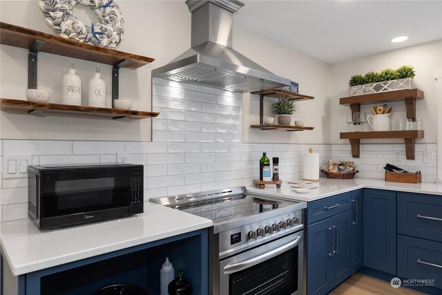 kitchen featuring stainless steel electric range, island exhaust hood, blue cabinetry, and decorative backsplash