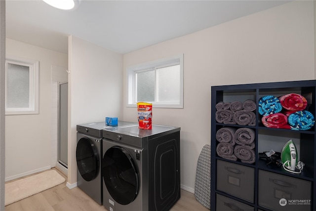 laundry room featuring light hardwood / wood-style floors and separate washer and dryer