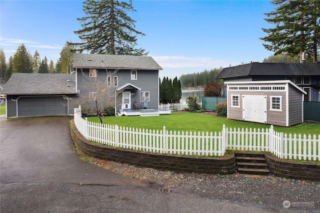 front facade with a front lawn, a storage unit, a garage, and a wooden deck