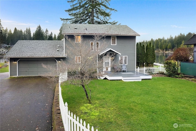 front facade with a front yard, a garage, and a wooden deck