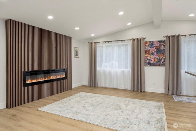 unfurnished living room featuring hardwood / wood-style floors and vaulted ceiling with beams