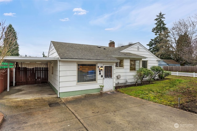 view of front of property featuring a front lawn and a carport