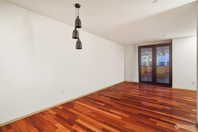 empty room with floor to ceiling windows, dark hardwood / wood-style flooring, and french doors