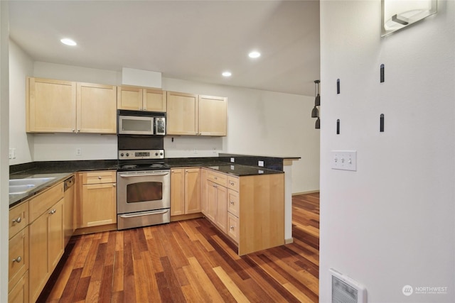 kitchen with sink, light brown cabinetry, dark hardwood / wood-style flooring, kitchen peninsula, and stainless steel appliances