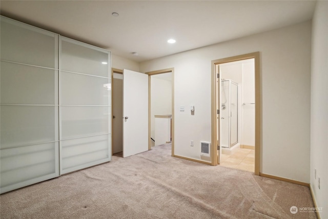 unfurnished bedroom with light carpet and ensuite bath