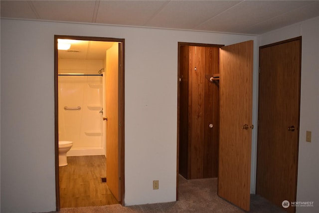 unfurnished bedroom featuring light carpet, a closet, and connected bathroom