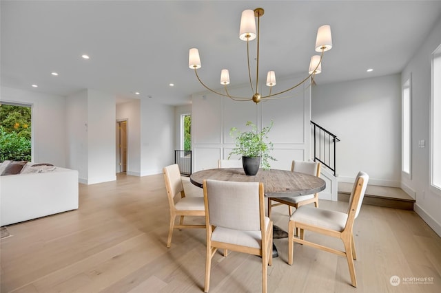 dining area with light wood-type flooring and a chandelier