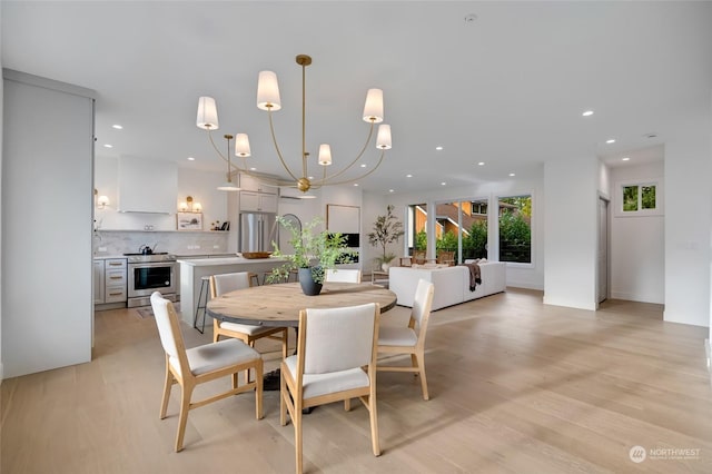 dining area featuring light hardwood / wood-style floors and an inviting chandelier