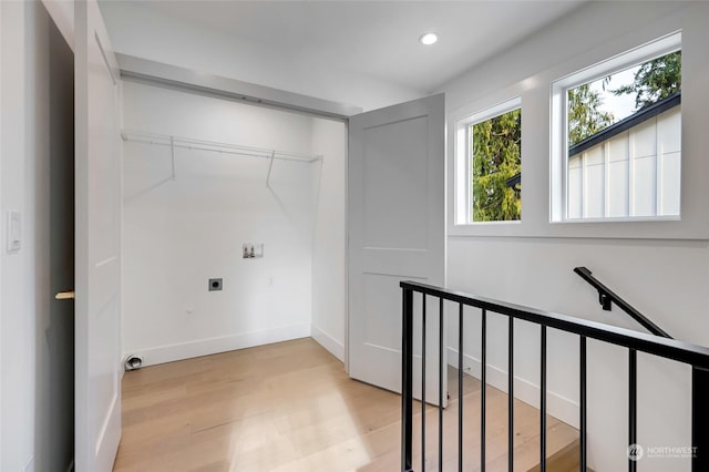 washroom featuring electric dryer hookup, light hardwood / wood-style floors, and washer hookup