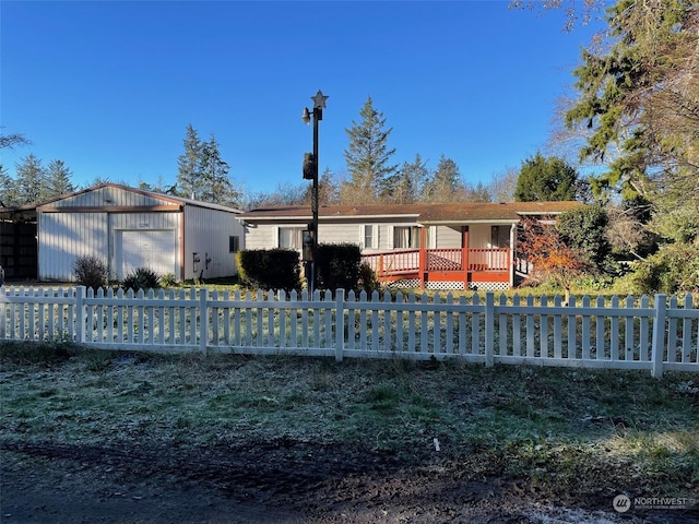 view of front of home with a deck, a garage, and an outdoor structure