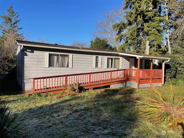 view of front of home featuring a deck and a front yard